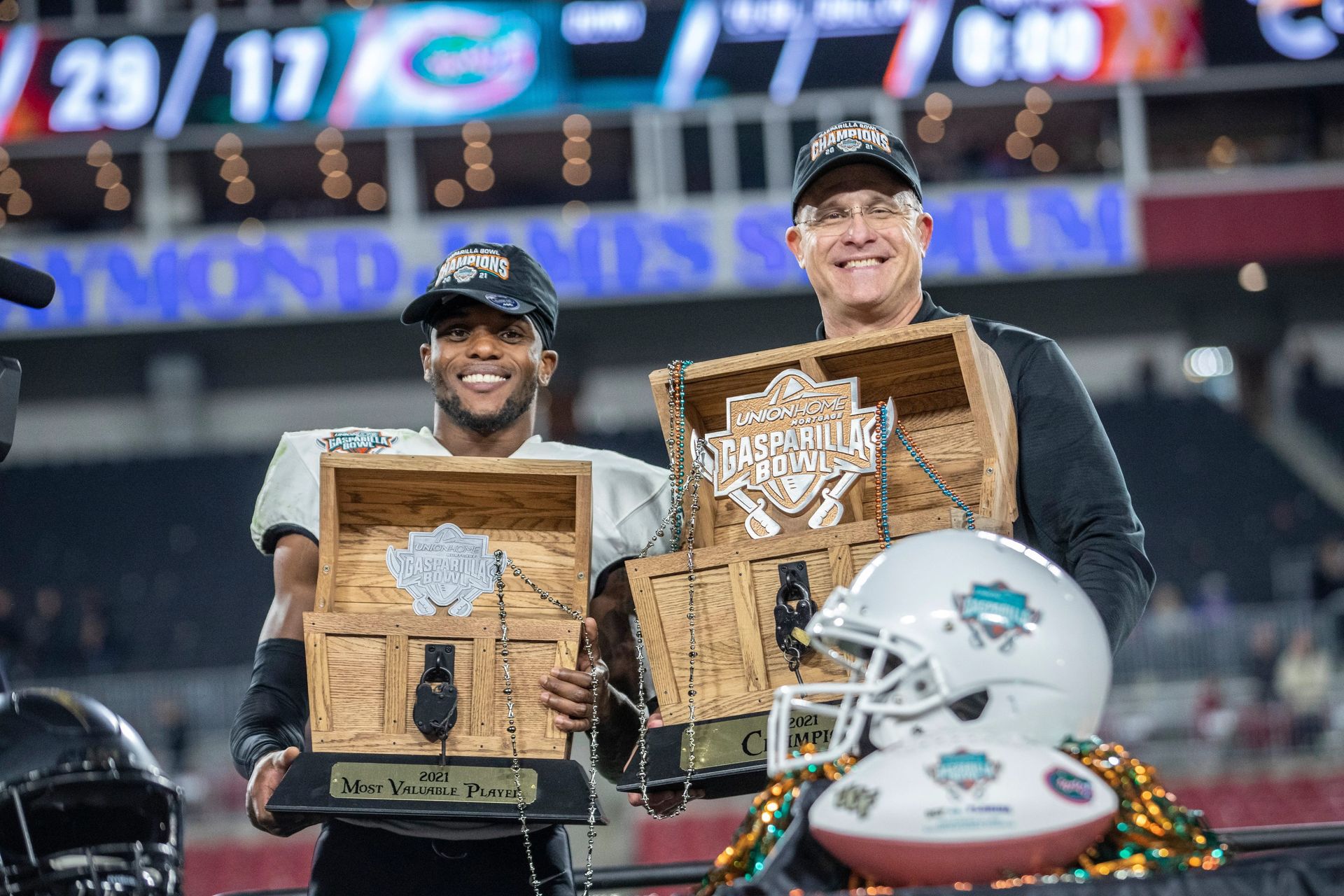 Athletes celebrating with custom trophies on the field